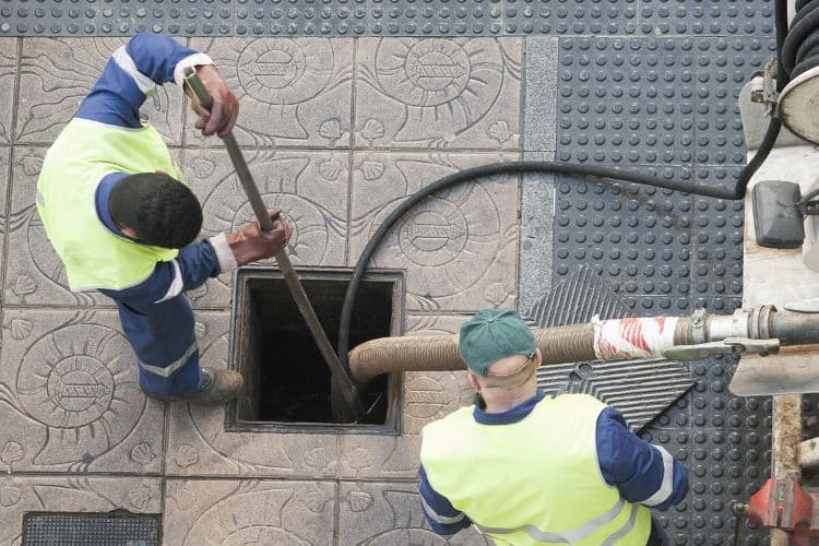 Municipal Utility workers cleaning a clog in the public sewer main