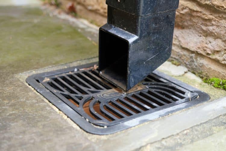 External pipe leading to drain with plastic drain grate over it
