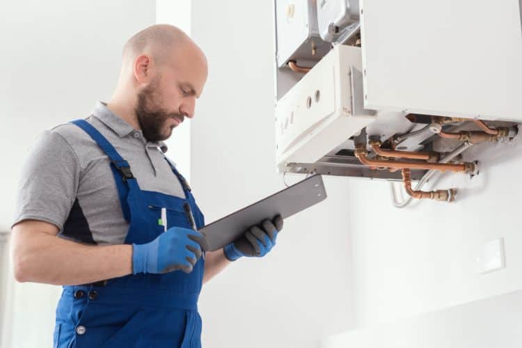 Gas engineer checking a hot water boiler