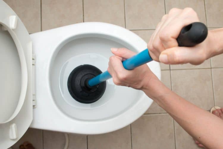 Unclogging a toilet with a plunger